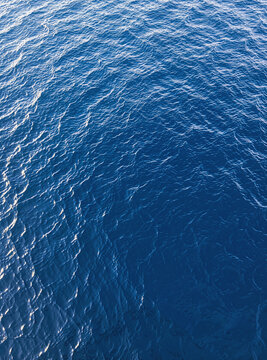 Calm ocean water with tiny ripples and wavelets near the horizon.