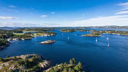 Fototapeta premium Lake scene in the countryside with boats and houses under clear blue sky