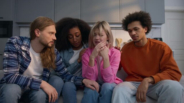 Sad crying woman frustrated on couch indoors breakup tears emotional female comforted by multiracial friends diversity multiethnic friendship support help console compassion together depression home