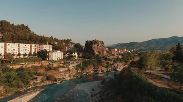 Scenic aerial view of the small town of Permet in Albania. The Vjosa river flows through the landscape, alongside the famous City Stone rock