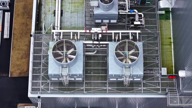 Two large cooling units and intricate pipe systems on an industrial rooftop. Useful for engineering or industrial infrastructure content.