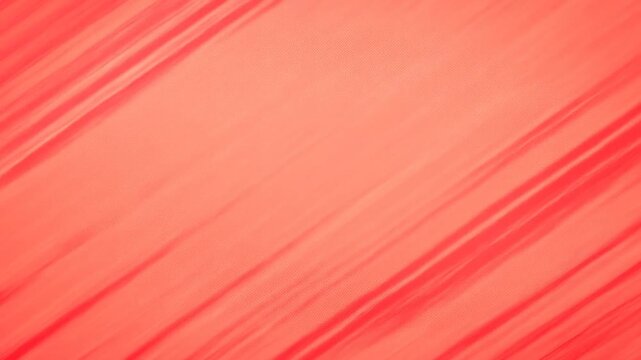 Panning shot of diagonal red stripe pattern on fabric sweeping across textured studio backdrop with motion blur and soft directional light