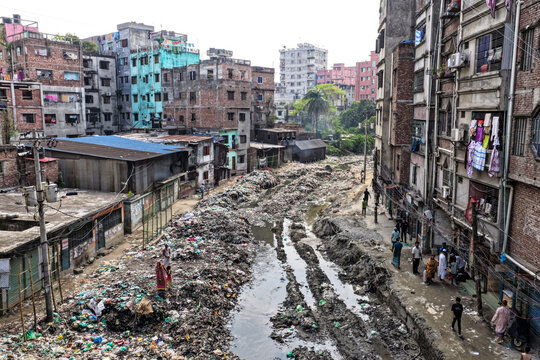 Keraniganj, Bangladesh - 11 April 2026: Aerial view of a severely polluted and muddy urban canal, choked with refuse, flanked by densely packed, colorful yet weathered residential buildings.