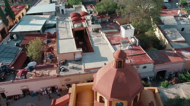 San Sebasti&aacute;n Church, Quer&eacute;taro, Baj&iacute;o, Mexico - A Historic Church Overlooking the Red-tiled Rooftops and Bustling Courtyards of the Neighborhood - Drone Flying Forward