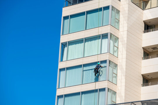 Window clean solo man works on high rise building, Fukuoka