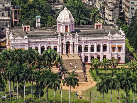 Dhaka, Bangladesh - 11 April 2026: Aerial view of the Ahsan Manzil, a pink palace rising above lush palm trees, its dome gleaming in the sunlight, a testament to architectural grandeur.