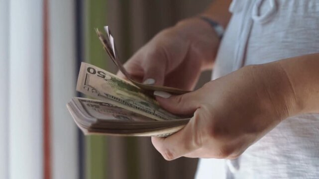 A woman counting dollar bills.