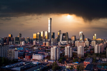 Obraz premium Beijing city skyline and architectural cluster under dramatic storm clouds and crepuscular rays, China