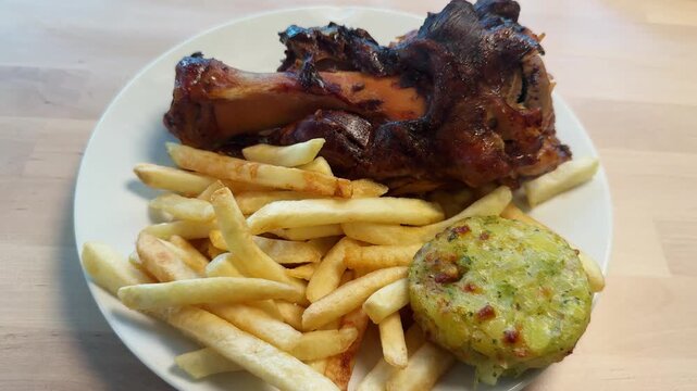 Pork knuckle served with crispy French fries on the table, tender, smoky, and packed with taste. High quality 4k footage