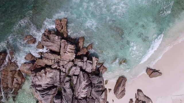 Bird eye drone view of granites stones near shoreline, clear turquoise water, white sandy beach, people snorkelling, anse cocos, La Digue, Seychelles 007