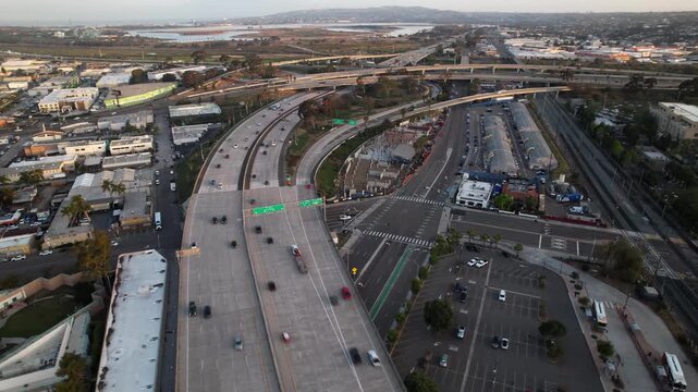 Drone flying east above Interstate 5 at 6AM looking toward Mission Bay with calm water and sunrise lighting.