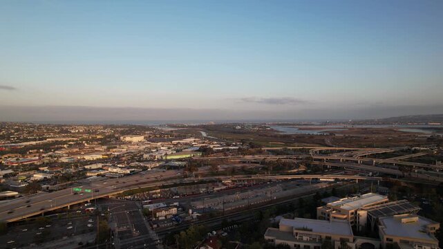 Drone flying forward toward the Interstate 5 and 8 freeway interchange at 6AM capturing traffic and infrastructure at sunrise.