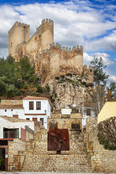 View of Almansa Castle from stone stairs in Albacete province, Spain. Medieval fortress architecture under cloudy sky in daytime