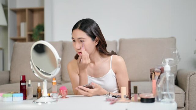 Woman applying skincare and makeup at home, glowing healthy skin, natural beauty routine with cosmetic products