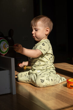 Toddler playing with toy in sunlit room Portrait