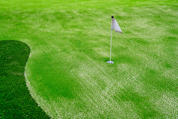 Obraz premium Artificial turf putt putt course with a visible cup and white flag