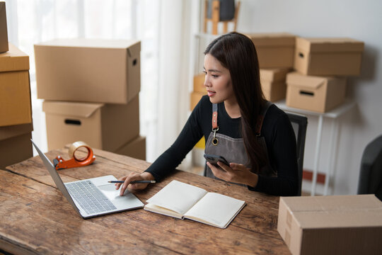 Small business owner managing online orders at desk