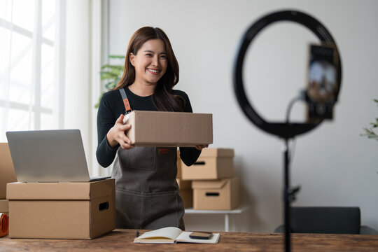 Young asian woman online seller presenting product package