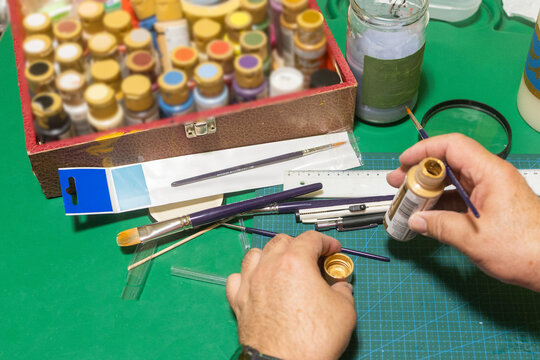 Man using paint and brush for creative model making hobby