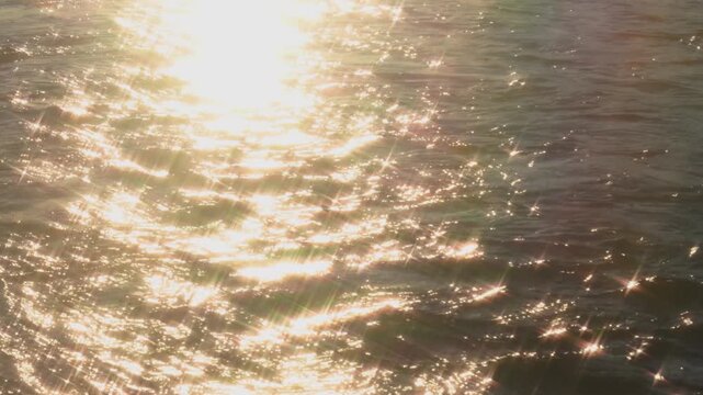 Sunny river ripples surface background with golden sun reflection shimmering on water