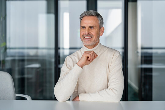 Smiling businessman sitting at a desk in an office