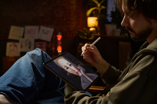 Illustrator drawing digital art on graphic tablet indoors