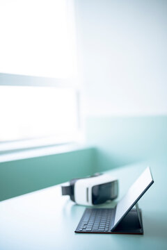 Tablet PC near virtual reality simulator on desk