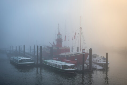Old red lightship moored in the foggy harbor of Hamburg