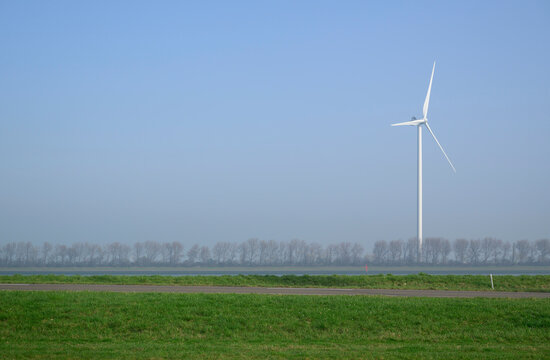 Wind turbine near canal and dyke in Rotterdam harbour the Netherlands