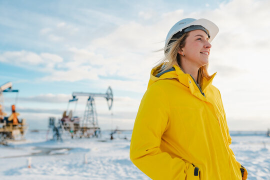 Smiling young engineer at oil production field in winter