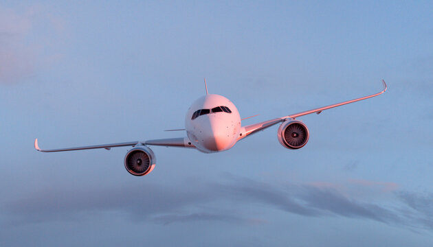 Front view of modern airplane flying in clear sky during sunset