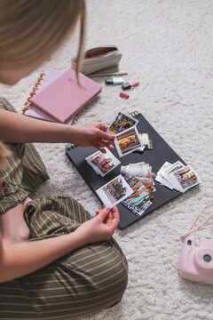 Woman sorting photographs for a handmade scrapbook album at home