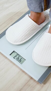 Person in White Slippers Stepping on Digital Bathroom Scale to Check Weight