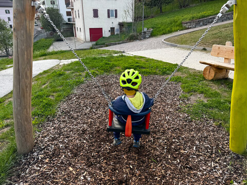bambino su altalena parco giochi 