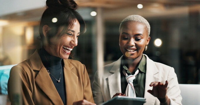Women, tablet and team at window in office at night, happy or funny chat at finance company. Business people, tech and app at glass wall, feedback report or laugh with asset management at agency