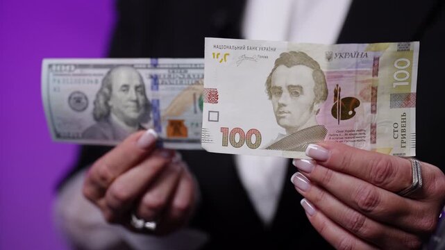 US $100 bill and a 100 Ukrainian hryvnia banknote studio shot. The composition highlights a direct comparison between global and local currencies, symbolizing exchange rates, international finance.
