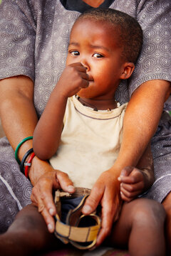 Basarwa San Child Portrait Being Held by an Adult old woman Kalahari Botswana