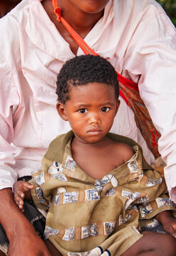 Basarwa San Child Portrait Being Held by an Adult old woman Kalahari Botswana