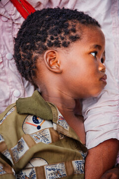 Basarwa San Child Portrait Being Held by an Adult woman Kalahari Botswana