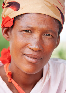 Full portrait of an old Basarwa San woman smile against a blurred natural background.