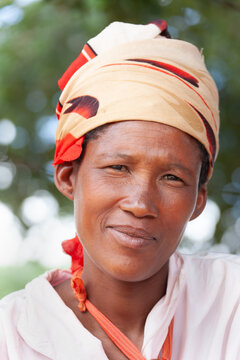 Basarwa San Woman Portrait Kalahari with a slight smile against a blurred natural background.