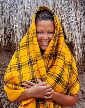 Basarwa San Woman Portrait Kalahari with a slight smile against a blurred natural background.