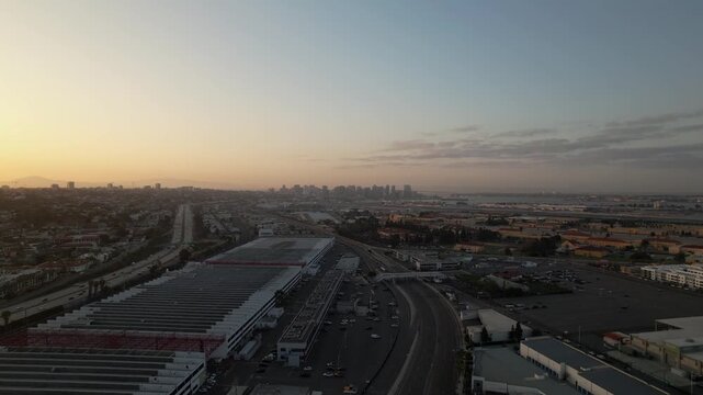 Drone flying forward at 6AM during sunrise capturing a wide view of the downtown San Diego skyline with soft morning light.