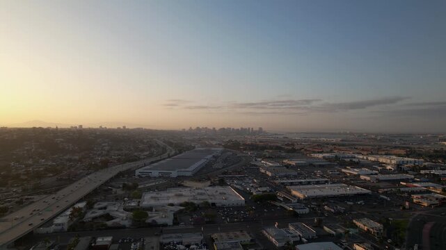Drone flying toward the warehouse district in downtown San Diego at 6AM capturing industrial buildings and morning light.