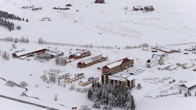 Las Le&ntilde;as ski resort village in Malarg&uuml;e Mendoza Argentina with hotels lodges and lifts across snow covered Andes valley, winter tourism infrastructure visible, smooth lateral drone slide establishing
