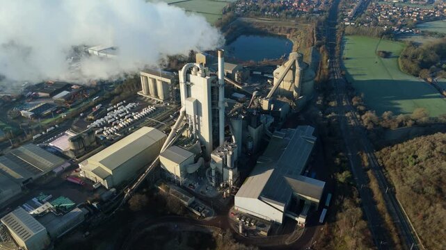 Cinematic drone orbit of the Rugby industrial landscape and heavy manufacturing cement works.