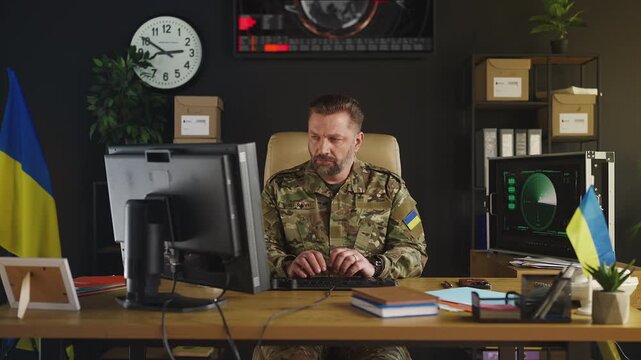 Ukrainian intelligence officer working on computer, planning military operations