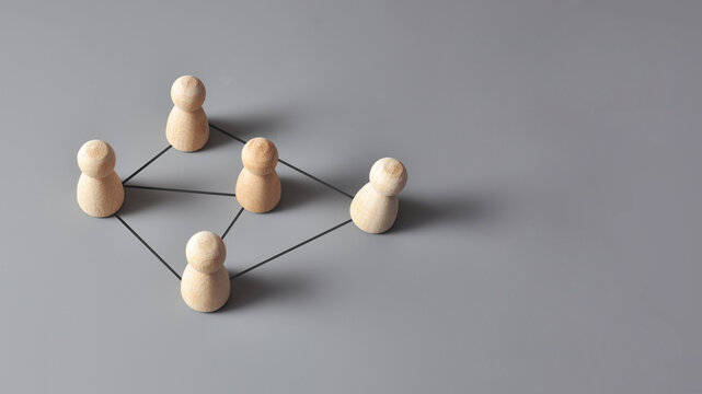 Connected team network with wooden figures, communication concept