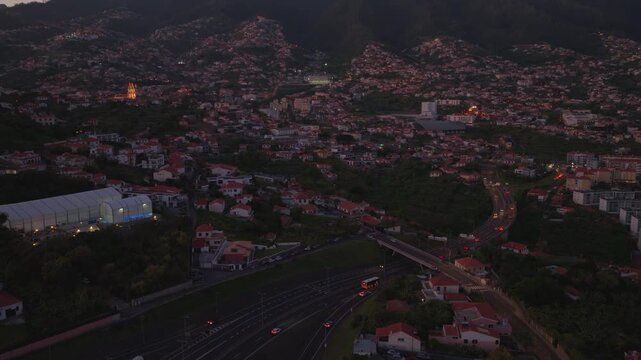 Aerial sunset view of hillside town with red roofed houses in Madeira
