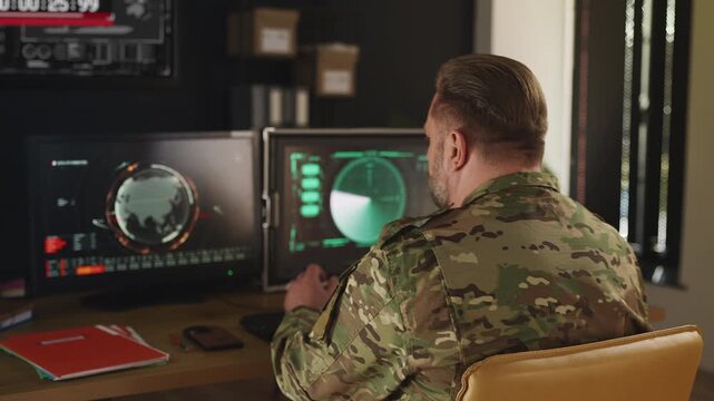 Ukraine intelligence officer tracking threats across multiple screens in office
